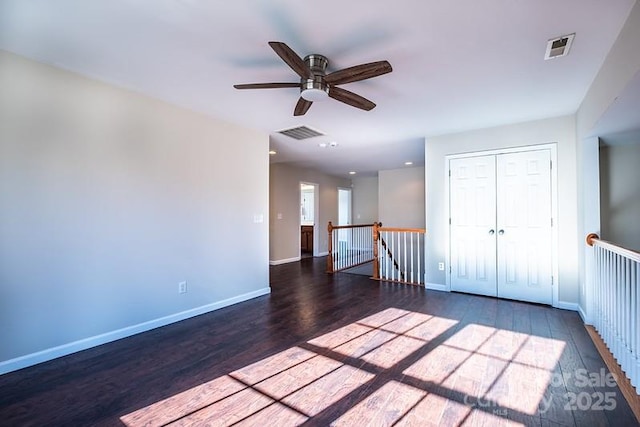 unfurnished room featuring wood finished floors, visible vents, and baseboards