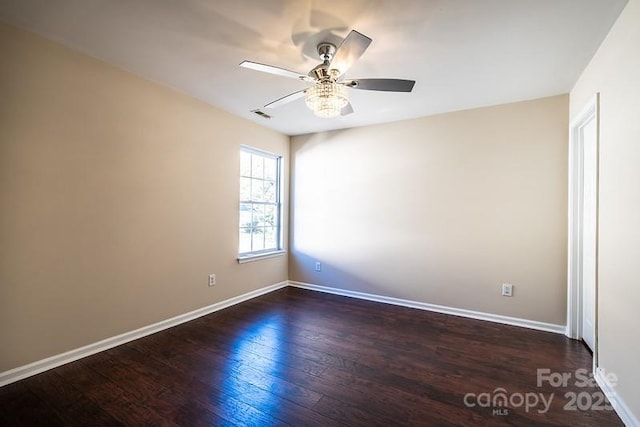 unfurnished room with baseboards, visible vents, ceiling fan, and dark wood-style flooring