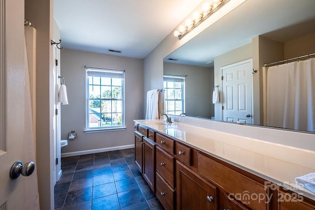 bathroom with visible vents, toilet, vanity, tile patterned flooring, and baseboards