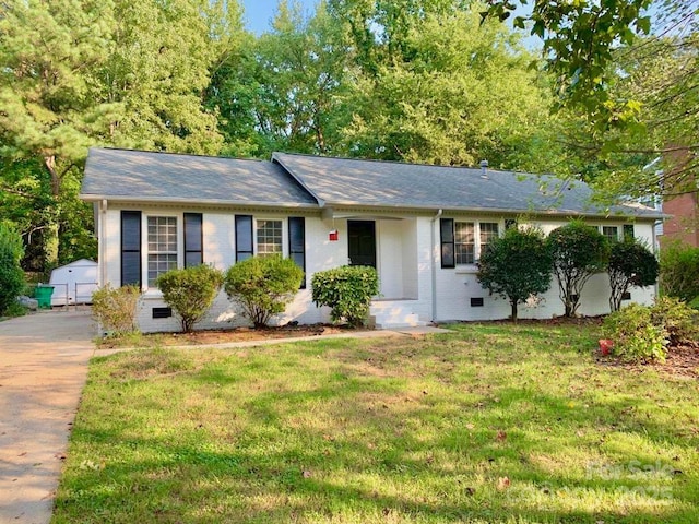 single story home with crawl space, brick siding, a shingled roof, and a front yard