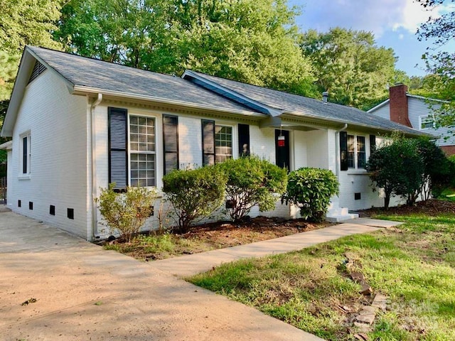 single story home featuring crawl space, brick siding, and roof with shingles