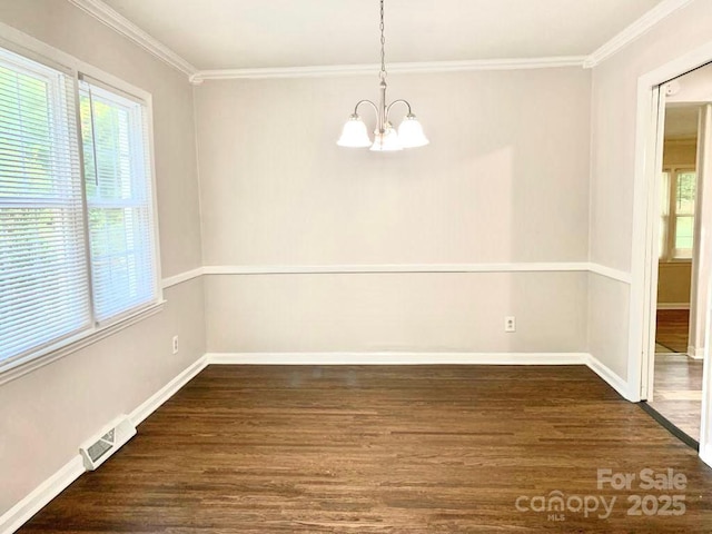 unfurnished dining area with dark wood-type flooring, visible vents, baseboards, an inviting chandelier, and crown molding