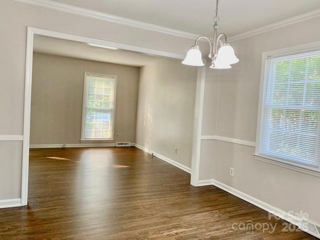 spare room with dark wood-type flooring, plenty of natural light, and crown molding