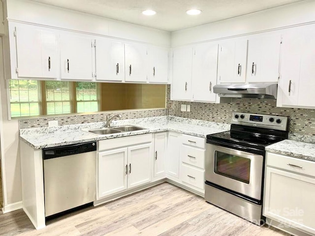 kitchen with appliances with stainless steel finishes, white cabinetry, light wood-style floors, and under cabinet range hood