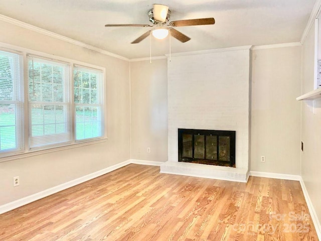 unfurnished living room featuring light wood-type flooring, a brick fireplace, and crown molding