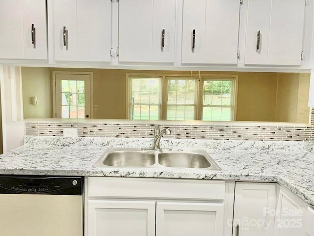 kitchen with plenty of natural light, dishwasher, backsplash, white cabinetry, and a sink