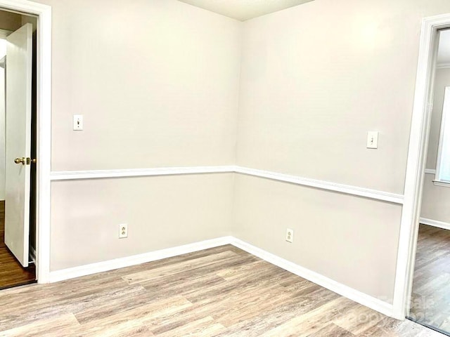 spare room featuring baseboards and wood finished floors