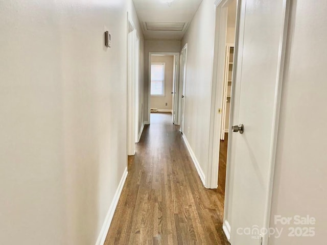 hall featuring attic access, baseboards, and wood finished floors