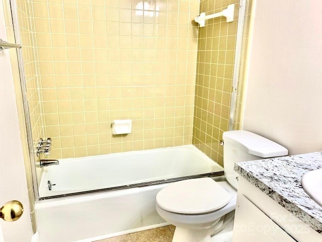 bathroom featuring toilet, tile patterned flooring, combined bath / shower with glass door, and vanity