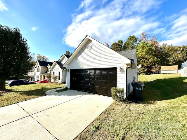 view of side of home featuring a garage and a lawn