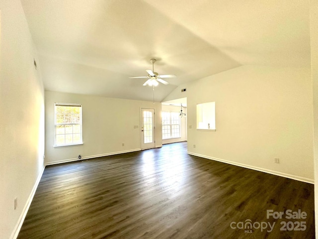 spare room with lofted ceiling, dark wood finished floors, a ceiling fan, and baseboards