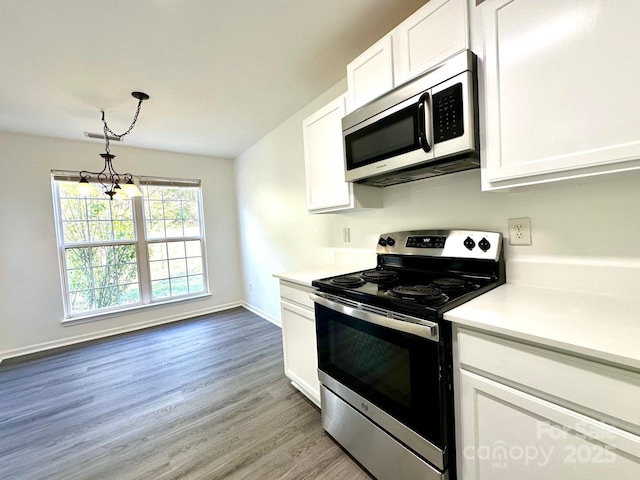 kitchen featuring light wood finished floors, white cabinetry, stainless steel appliances, and light countertops