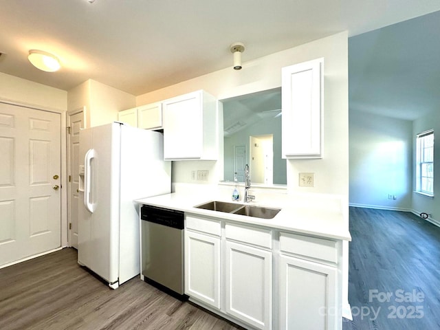 kitchen featuring white cabinets, wood finished floors, light countertops, stainless steel dishwasher, and a sink