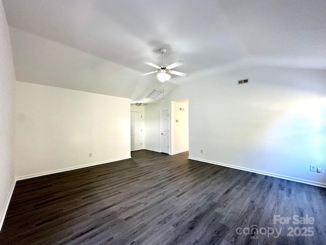 interior space featuring lofted ceiling, dark wood-style floors, visible vents, and baseboards