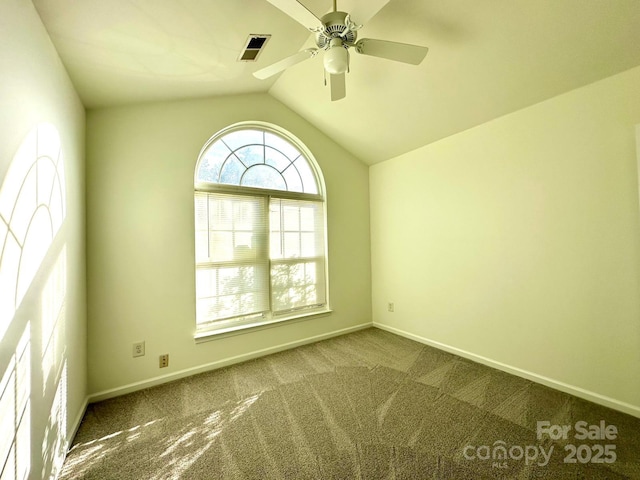 carpeted spare room with lofted ceiling, visible vents, ceiling fan, and baseboards