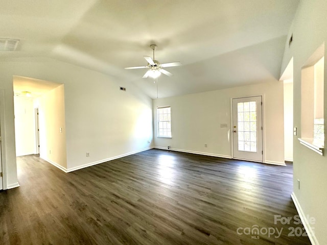 unfurnished living room with dark wood-style floors, visible vents, vaulted ceiling, ceiling fan, and baseboards