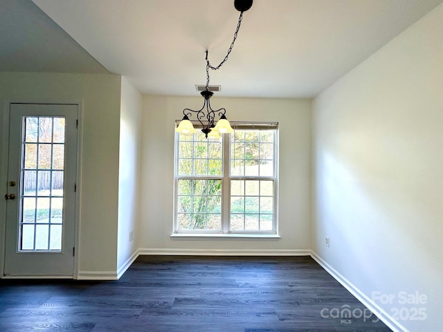 unfurnished dining area with dark wood-style floors, visible vents, baseboards, and a notable chandelier