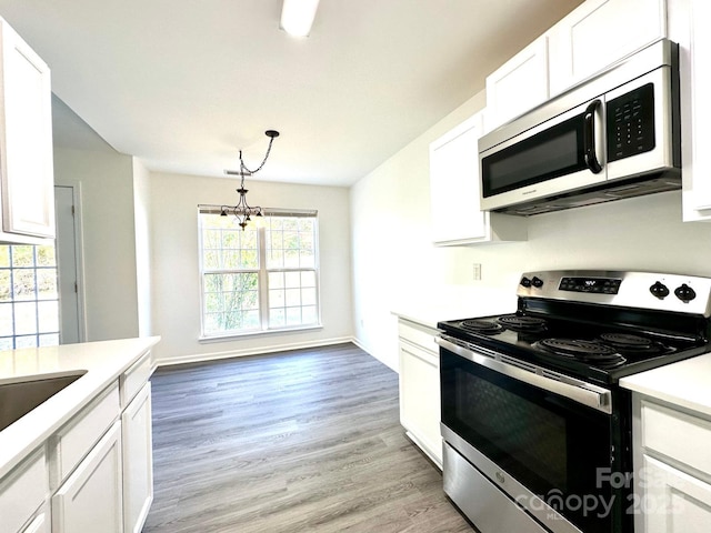 kitchen with white cabinets, light wood finished floors, stainless steel appliances, and light countertops