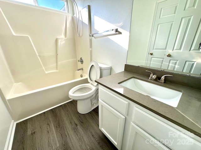 full bathroom featuring washtub / shower combination, vanity, wood finished floors, and toilet