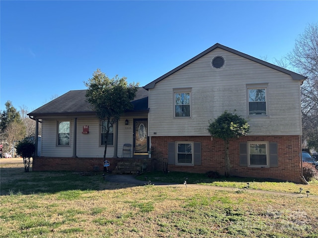 split level home with a front lawn and brick siding