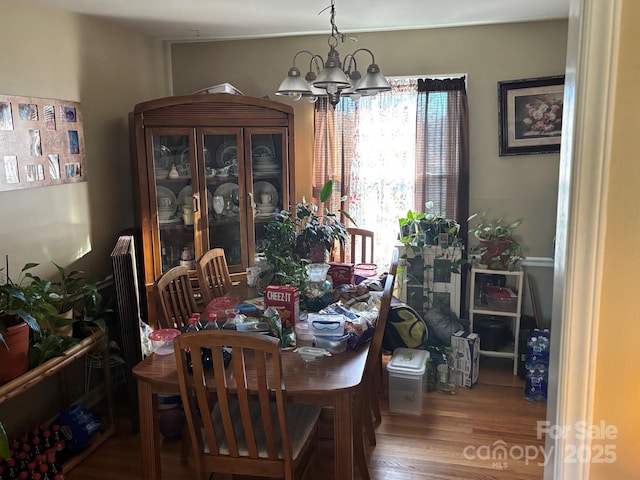 dining space with an inviting chandelier and wood finished floors