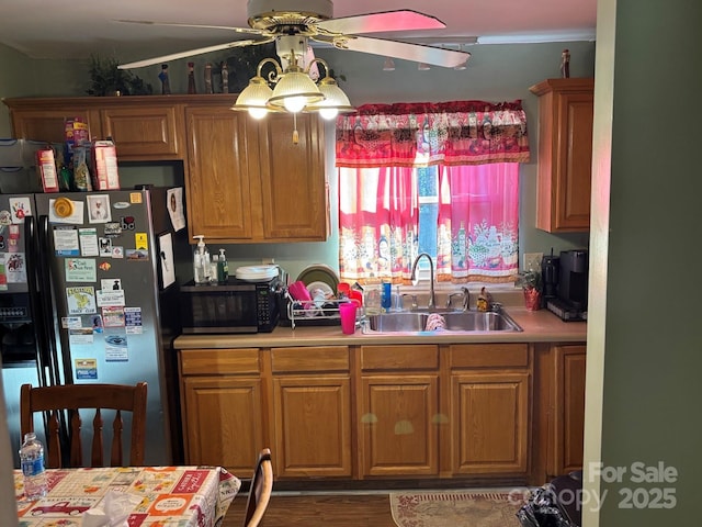 kitchen with light countertops, a sink, stainless steel fridge with ice dispenser, and ceiling fan