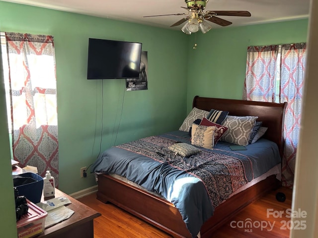 bedroom with ceiling fan, baseboards, and wood finished floors