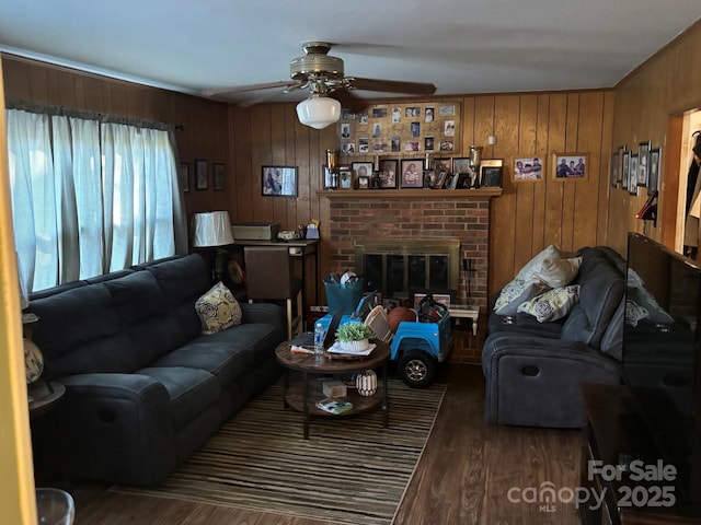 living room with a ceiling fan, wooden walls, and wood finished floors