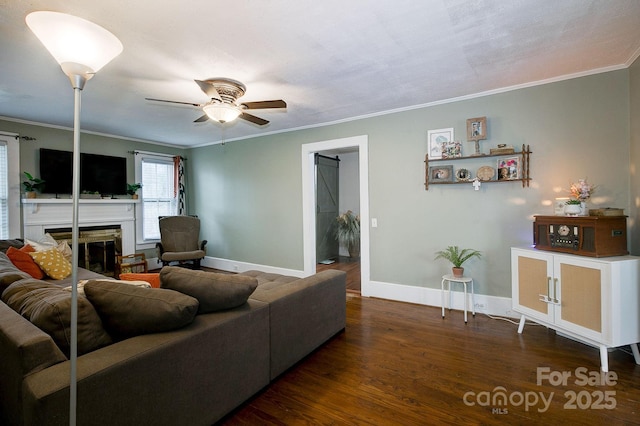 living area with a fireplace, crown molding, baseboards, and wood finished floors