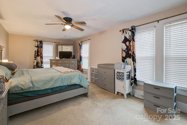 bedroom with light colored carpet and a ceiling fan