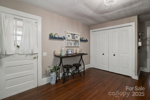 entrance foyer featuring baseboards, dark wood-type flooring, and a textured ceiling