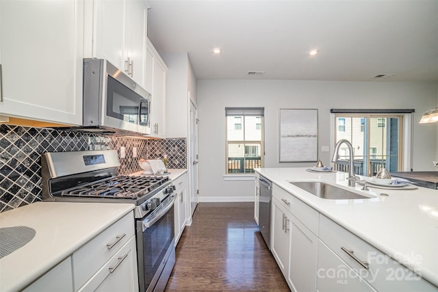 kitchen featuring stainless steel appliances, visible vents, backsplash, white cabinetry, and a sink