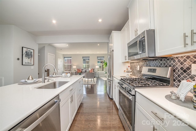 kitchen featuring dark wood finished floors, appliances with stainless steel finishes, light countertops, white cabinetry, and a sink