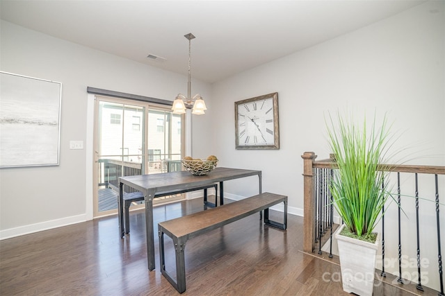 dining space featuring baseboards, visible vents, an inviting chandelier, and wood finished floors