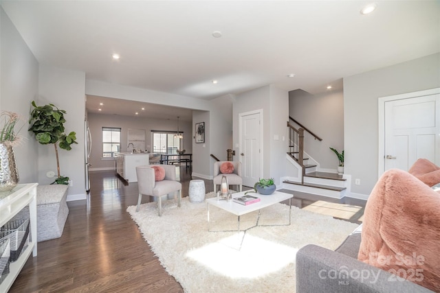 living area featuring baseboards, stairway, dark wood-style flooring, and recessed lighting