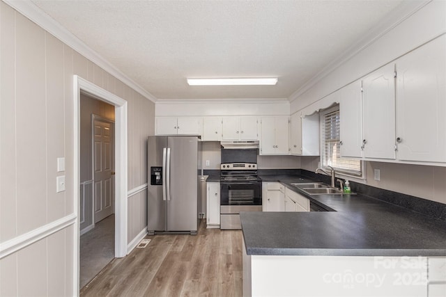 kitchen with under cabinet range hood, a sink, ornamental molding, appliances with stainless steel finishes, and dark countertops