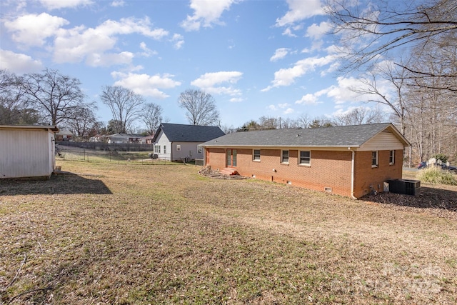 rear view of property with a lawn, crawl space, fence, cooling unit, and brick siding