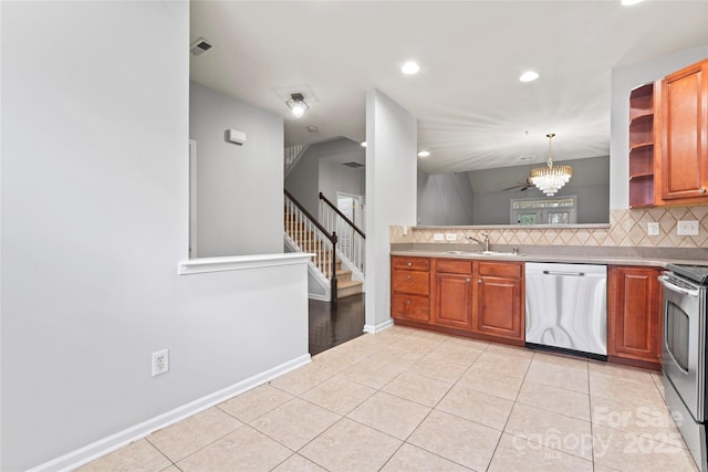 kitchen featuring light tile patterned floors, tasteful backsplash, light countertops, appliances with stainless steel finishes, and a sink