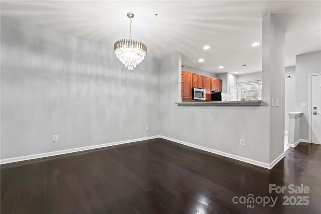 interior space featuring baseboards, a chandelier, dark wood-type flooring, and recessed lighting