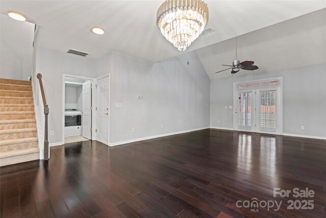 unfurnished living room featuring ceiling fan with notable chandelier, vaulted ceiling, stairway, and wood finished floors