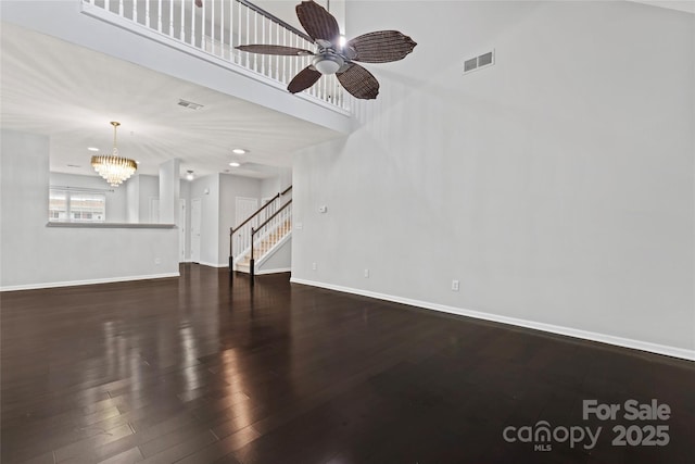 living area with stairs, visible vents, baseboards, and wood finished floors