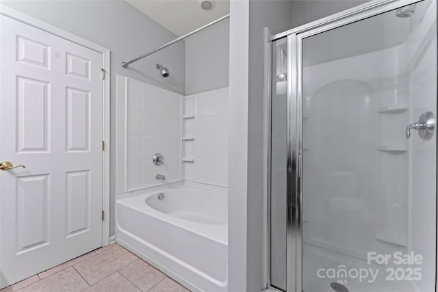 bathroom featuring a washtub, a shower with door, and tile patterned floors