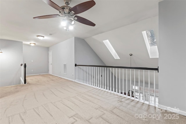 additional living space featuring vaulted ceiling with skylight, carpet flooring, and baseboards