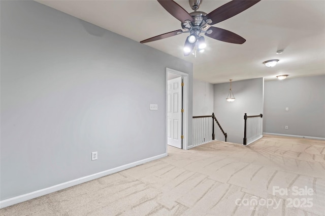 unfurnished room with a ceiling fan, carpet, and baseboards