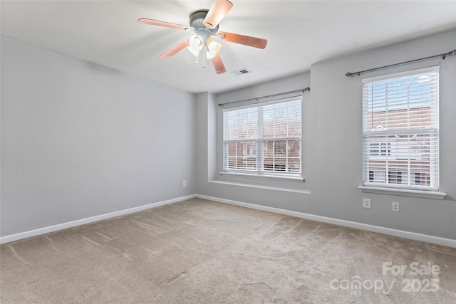 carpeted empty room with ceiling fan, visible vents, and baseboards