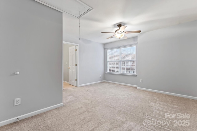 spare room with attic access, baseboards, ceiling fan, and carpet flooring