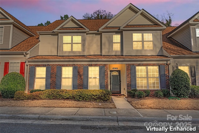 view of front of home featuring brick siding and a shingled roof