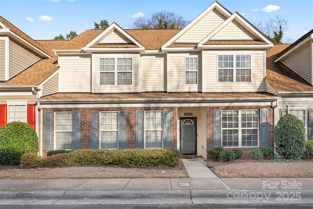 townhome / multi-family property featuring brick siding and a shingled roof