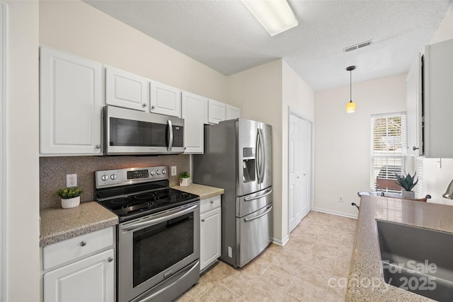 kitchen with visible vents, white cabinetry, stainless steel appliances, and light countertops