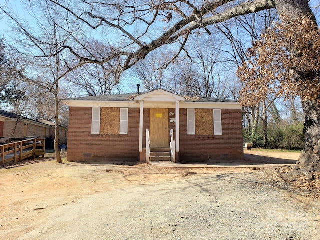 view of front of house featuring entry steps, brick siding, and crawl space